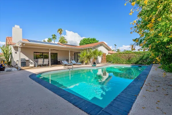 a view of a house with swimming pool and a yard