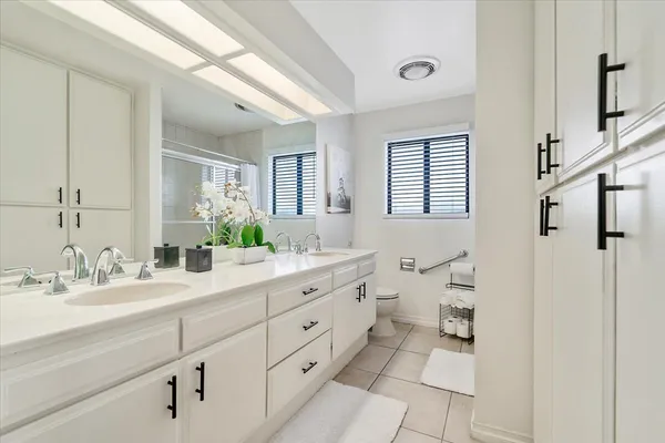 a spacious bathroom with a double vanity sink a mirror and a shower