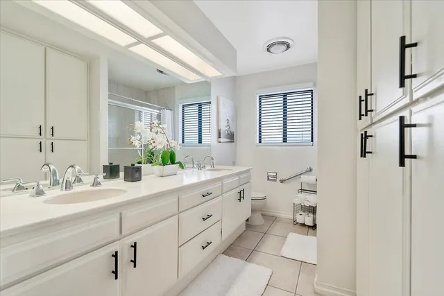 a spacious bathroom with a double vanity sink a mirror and a shower