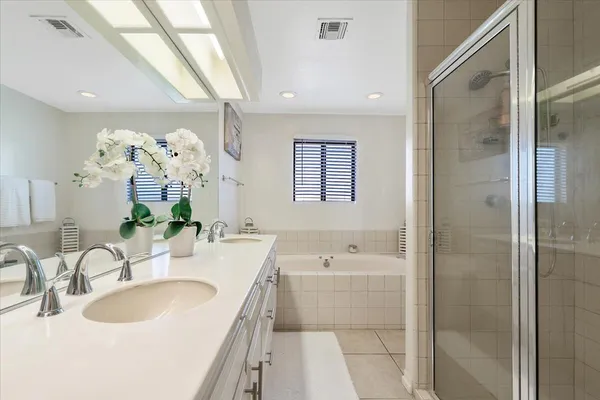 a bathroom with a tub sink double and mirror