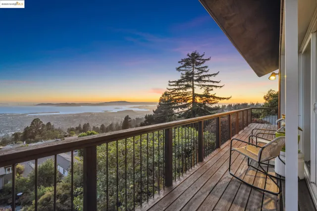 a view of a balcony with wooden floor & fence