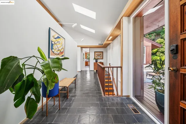 a hallway with table and a potted plant