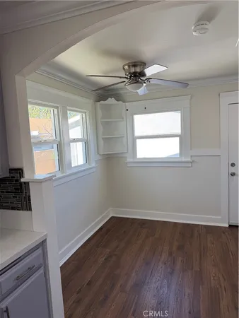 a view of an empty room with a window and wooden floor
