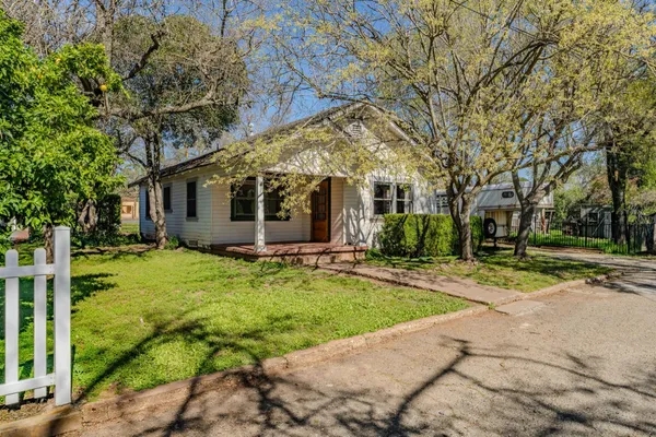 a view of a house with backyard and tree