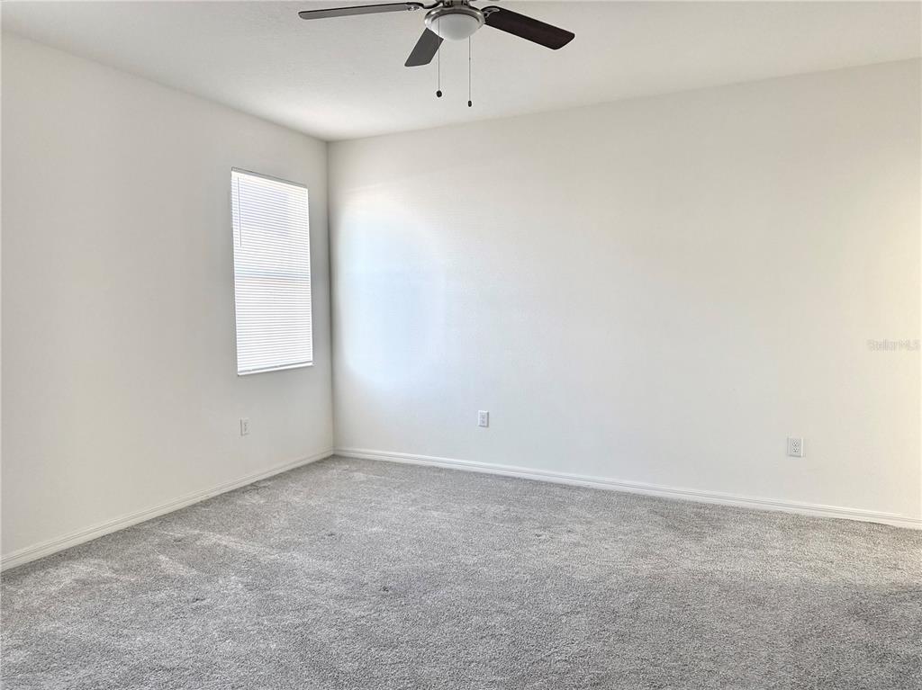 9023 Hooton Way Davenport, FL 33896 - Photo 11 of 25 an empty room with a ceiling fan and window