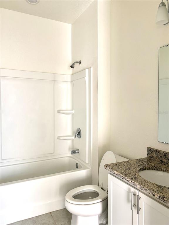 9023 Hooton Way Davenport, FL 33896 - Photo 13 of 25 a bathroom with a granite countertop sink toilet and shower