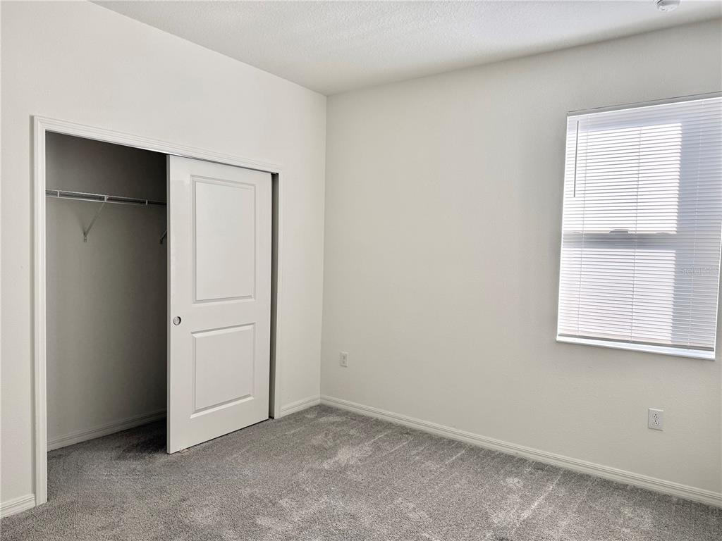 9023 Hooton Way Davenport, FL 33896 - Photo 17 of 25 an empty room with windows and closet