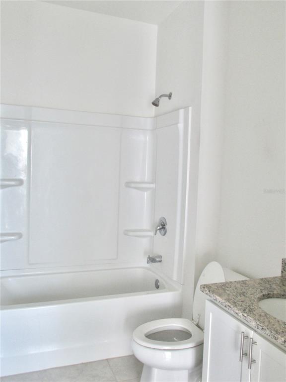 9023 Hooton Way Davenport, FL 33896 - Photo 19 of 25 a bathroom with a granite countertop bathtub toilet and sink