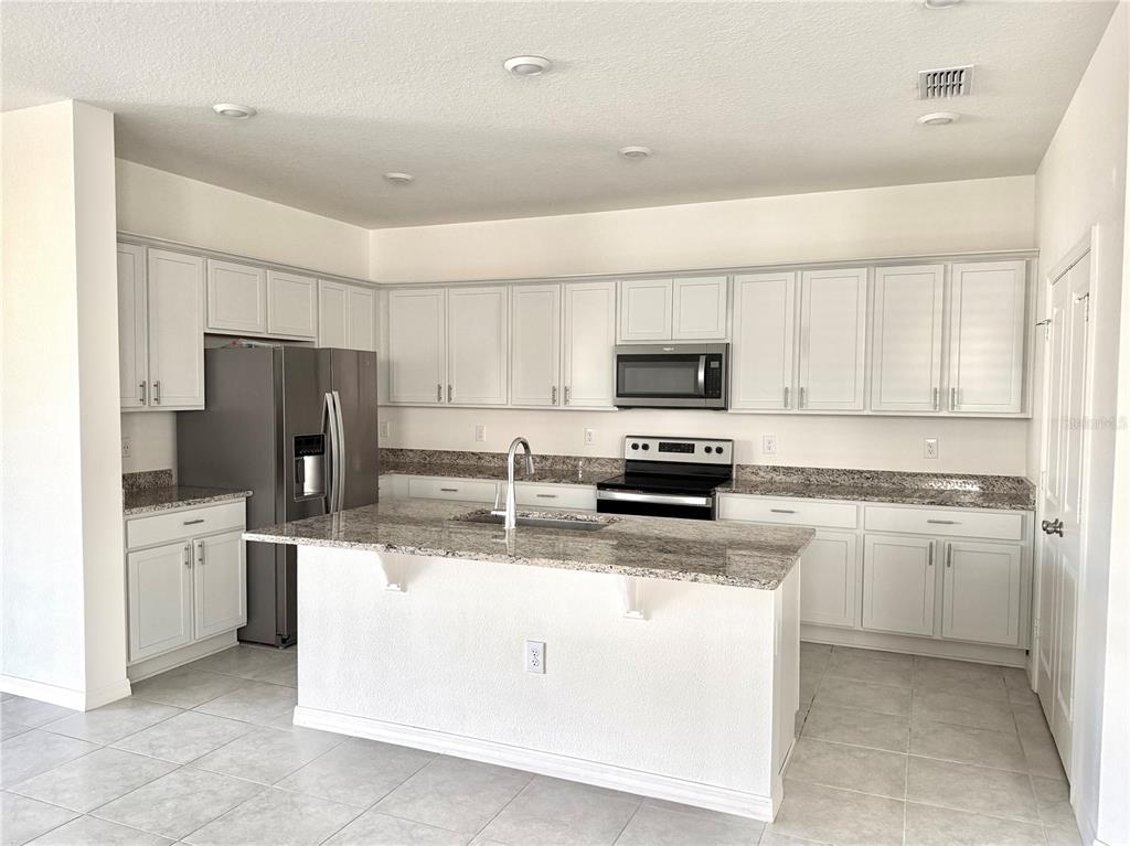 9023 Hooton Way Davenport, FL 33896 - Photo 2 of 25 a kitchen with stainless steel appliances a refrigerator stove microwave and sink