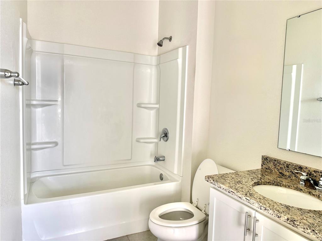 9023 Hooton Way Davenport, FL 33896 - Photo 22 of 25 a bathroom with a granite countertop sink toilet and shower