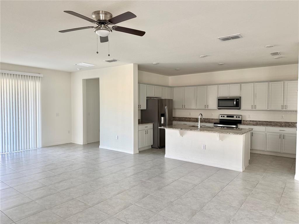 9023 Hooton Way Davenport, FL 33896 - Photo 4 of 25 a view of kitchen with stainless steel appliances a refrigerator and a stove top oven