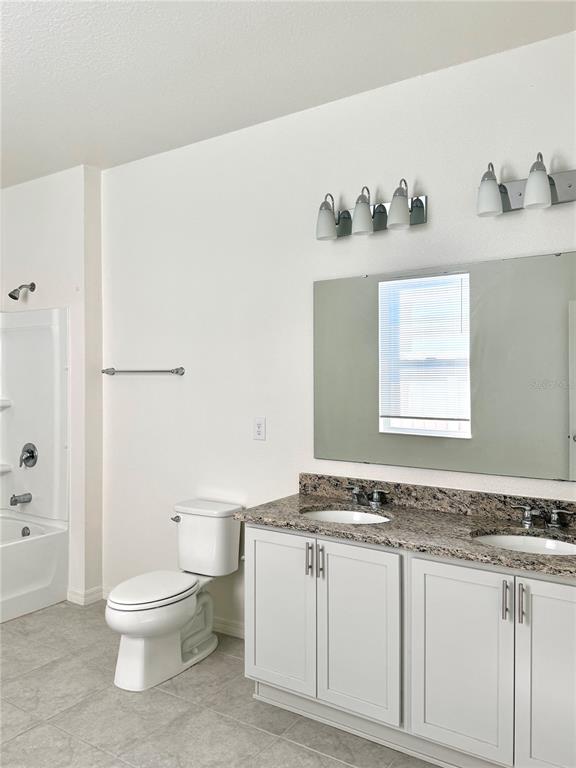 9023 Hooton Way Davenport, FL 33896 - Photo 9 of 25 a bathroom with a granite countertop sink and a toilet