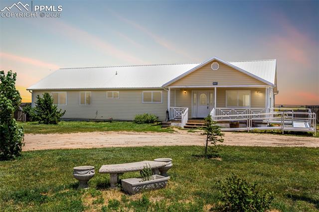 6065 Mulberry Road Calhan, CO 80808 - Photo 2 of 45 View of front of property with a front yard, covered porch, and a metal roof