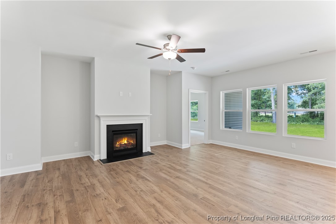3117 Wolfpack Lane Eastover, NC 28312 - Photo 18 of 45 a view of an empty room with wooden floor fireplace and a window