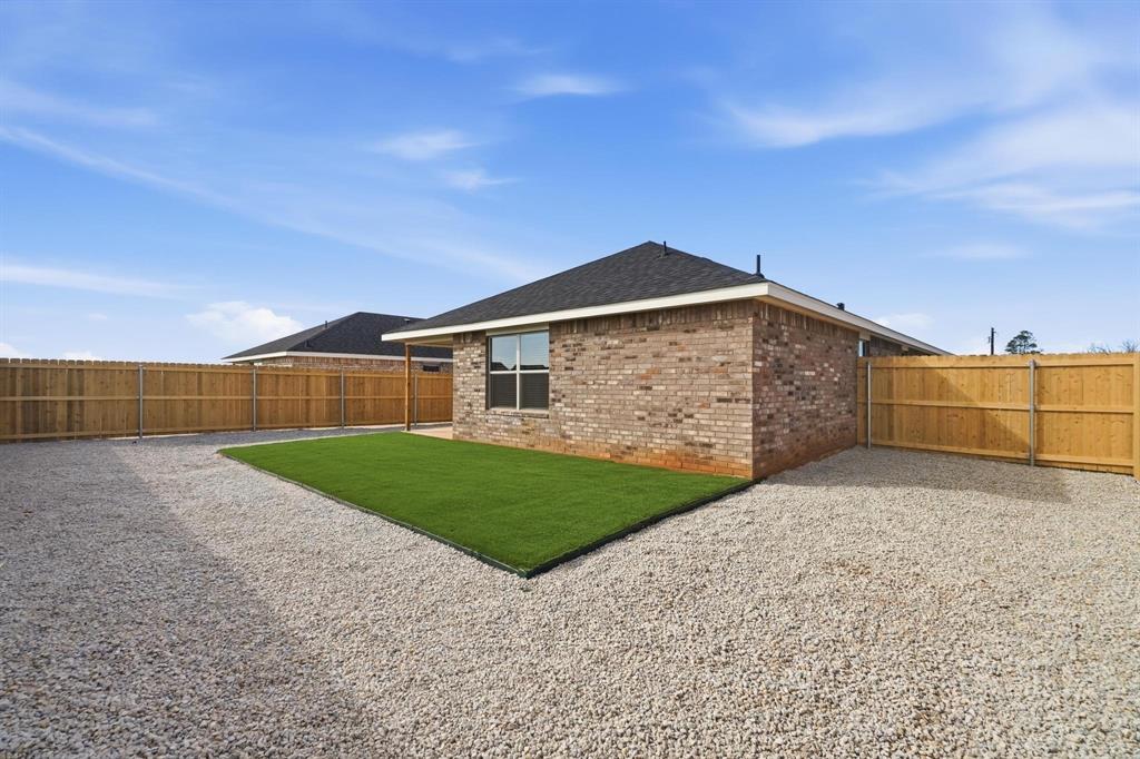 4165 Ranger Road Abilene, TX 79601 - Photo 10 of 10 Rear view of property featuring brick siding, a fenced backyard, a patio, and a shingled roof