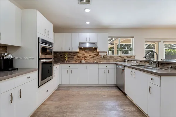 a kitchen with granite countertop a stove sink and cabinets
