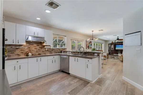 a kitchen with granite countertop a sink stove and cabinets