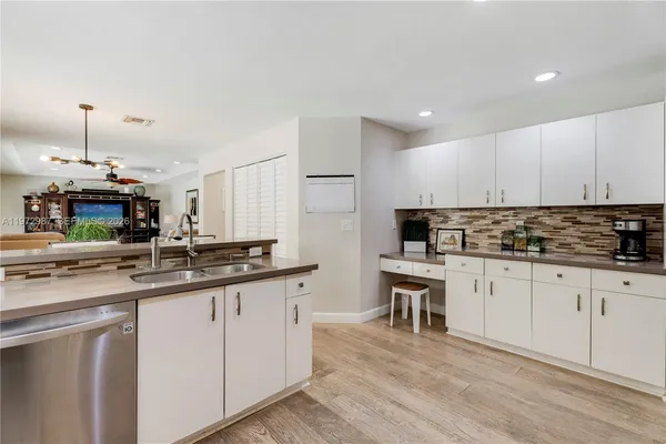 a kitchen with granite countertop a sink and cabinets
