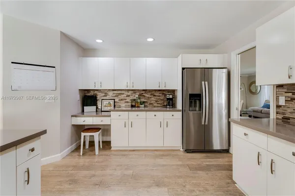 a kitchen with white cabinets and stainless steel appliances