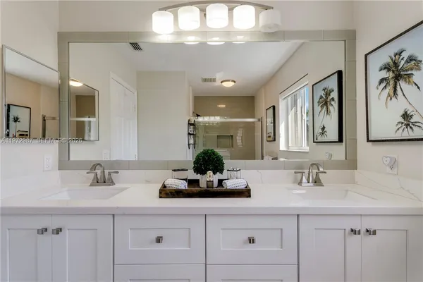 a bathroom with a sink double vanity and a mirror