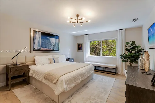 a bedroom with a large bed and a chandelier