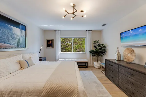 a bedroom with a large bed and a chandelier