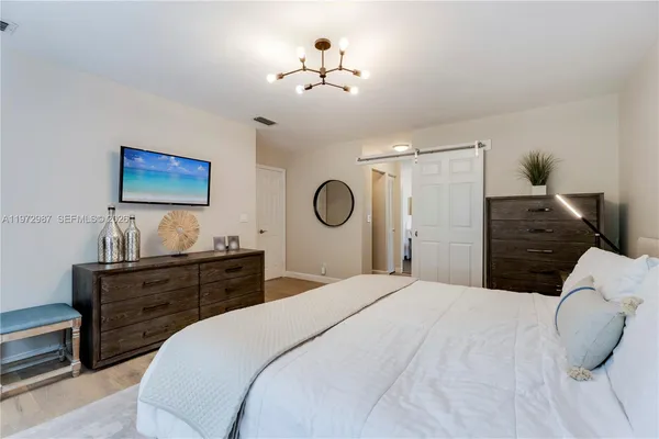 a bedroom with a bed and a chandelier