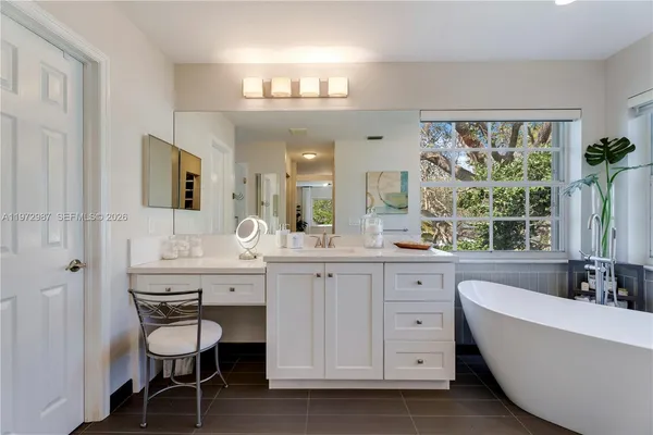 a spacious bathroom with a granite countertop sink mirror and a bathtub