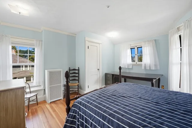 a bedroom with a bed and a wooden floor