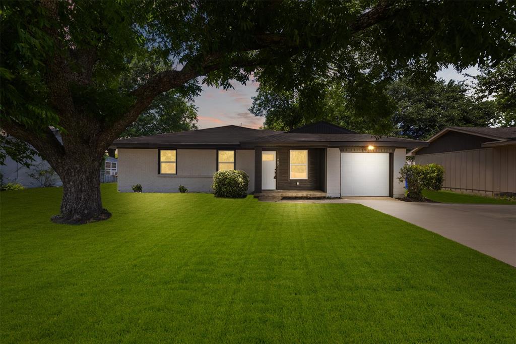 907 Pinson Road Forney, TX 75126 - Photo 2 of 35 Single-story residence featuring a white brick exterior, a dark shingle roof, and a prominent mature tree providing ample shade