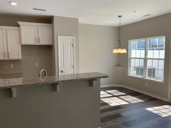 a kitchen with granite countertop a sink a window and stainless steel appliances