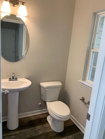 a bathroom with a toilet sink and mirror