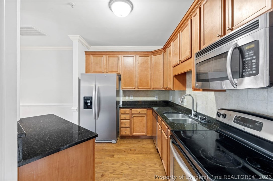 62 Gallery Drive, Unit 102 Spring Lake, NC 28390 - Photo 8 of 23 a kitchen with stainless steel appliances granite countertop a refrigerator a stove and a sink with wooden cabinets