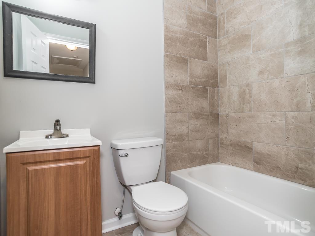 512 Dacian Road Raleigh, NC 27610 - Photo 12 of 19 a white toilet sitting next to a bathroom sink and vanity