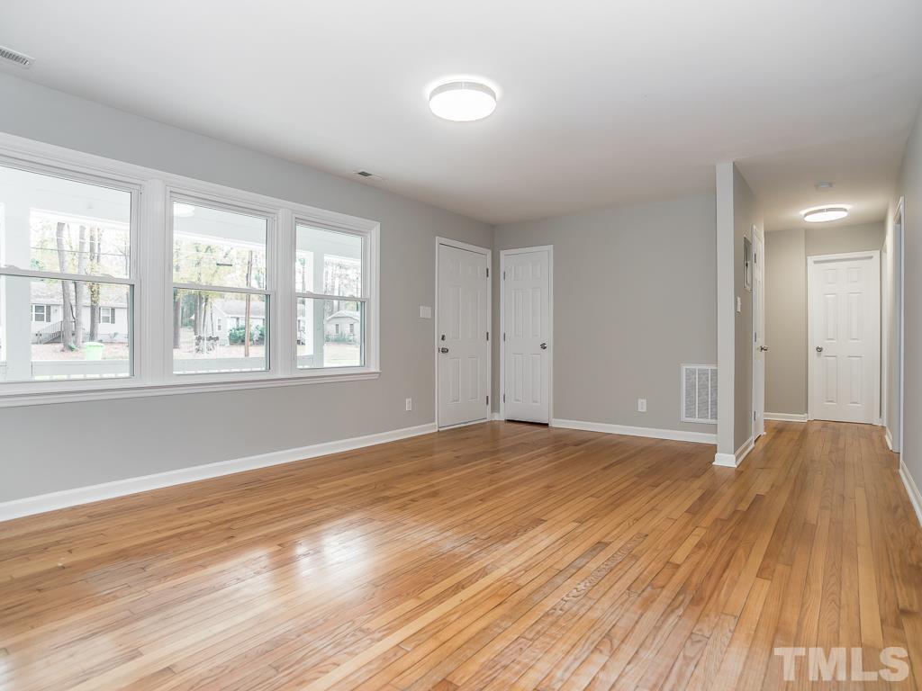 512 Dacian Road Raleigh, NC 27610 - Photo 5 of 19 a view of an empty room with wooden floor and a window