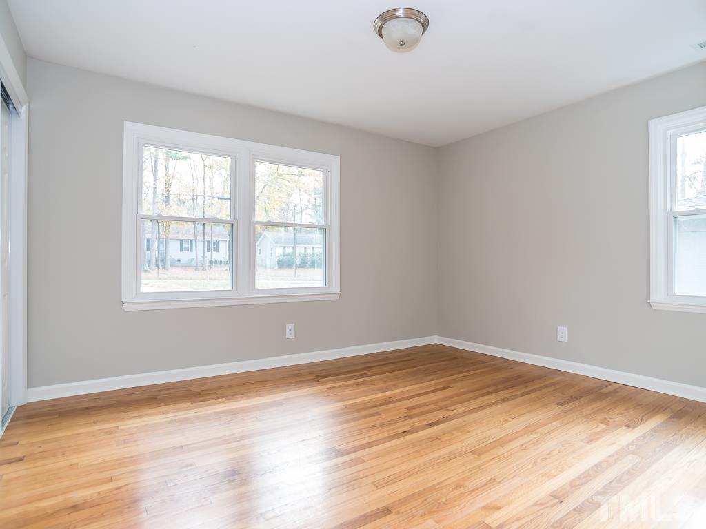 512 Dacian Road Raleigh, NC 27610 - Photo 6 of 19 a view of an empty room with wooden floor and a window