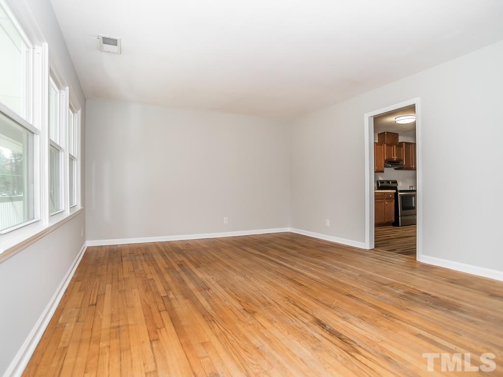 512 Dacian Road Raleigh, NC 27610 - Photo 9 of 19 a view of an empty room with wooden floor and a window