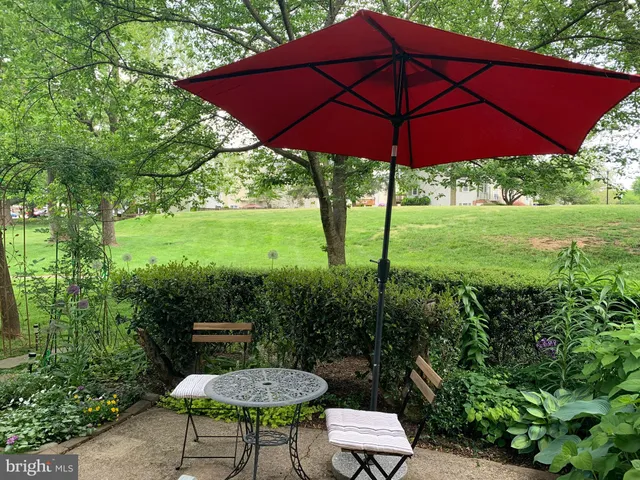 a view of a chair and table in the garden