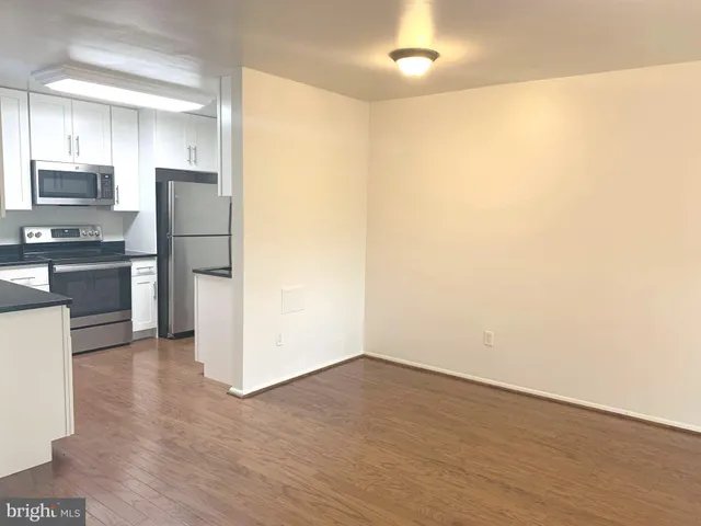 a view of a refrigerator in kitchen and wooden floor
