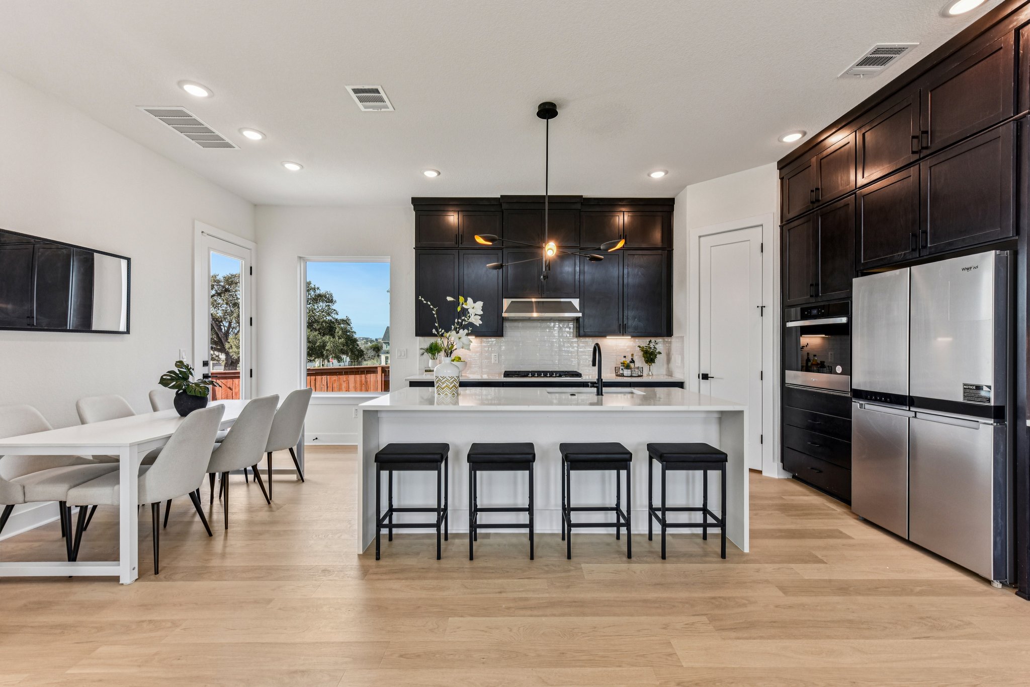 12105 Cearley Drive Austin, TX 78758 - Photo 11 of 40 a kitchen with stainless steel appliances granite countertop a dining table chairs refrigerator and microwave