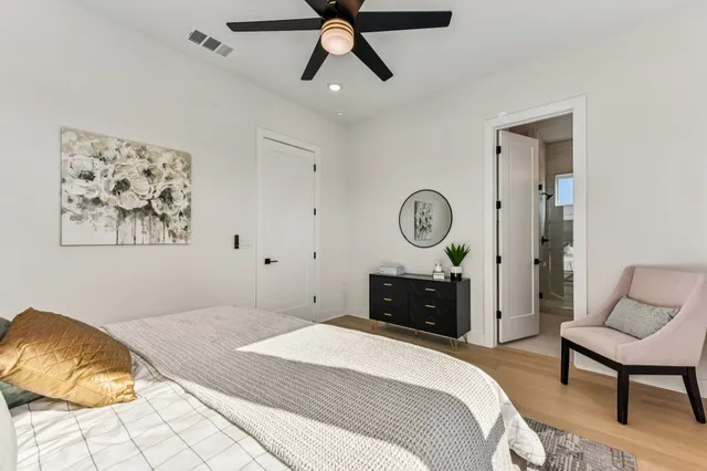 a bedroom with a bed window and a chandelier