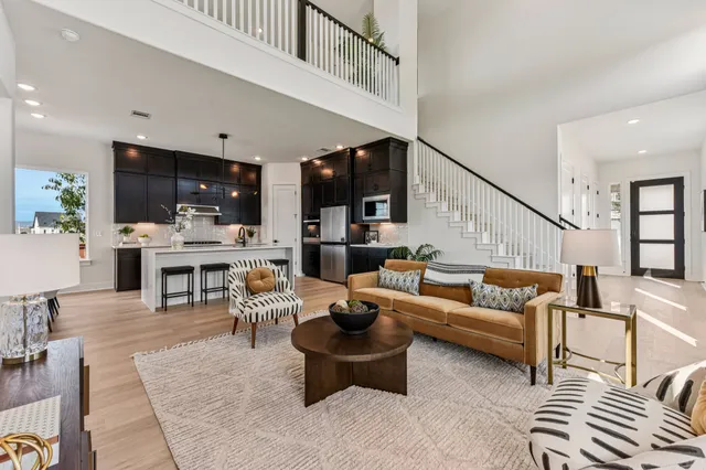 a living room with furniture kitchen view and a flat screen tv