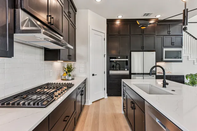a kitchen with stainless steel appliances a sink stove and cabinets
