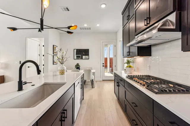 a kitchen with counter top space a stove a sink and cabinets