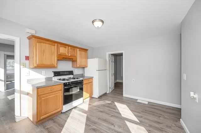 a kitchen with stainless steel appliances granite countertop a stove top oven a sink and a refrigerator