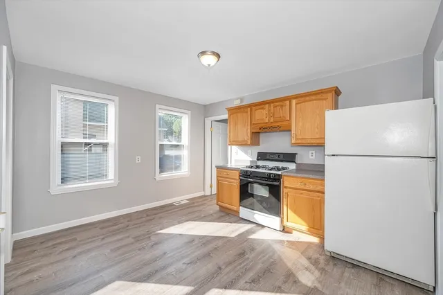 a kitchen with a refrigerator a stove top oven a sink and dishwasher with wooden floor