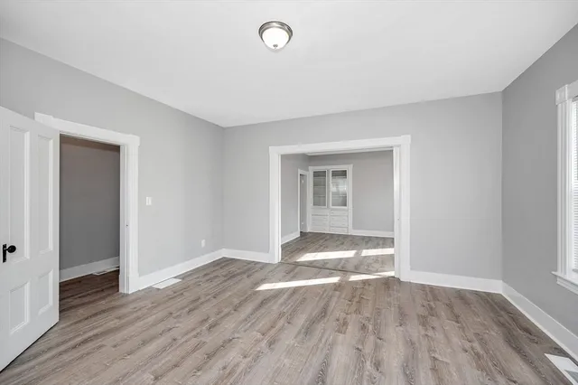 a view of empty room with wooden floor