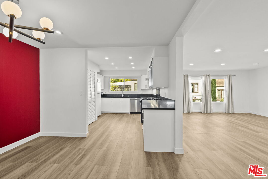 a view of kitchen with kitchen island microwave and wooden floor