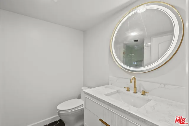 a bathroom with a sink a mirror and toilet