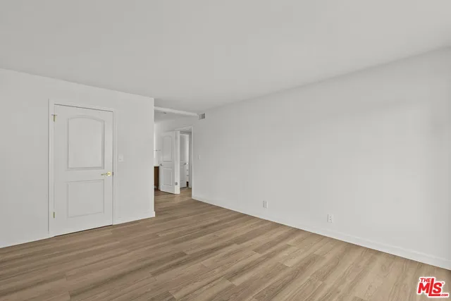 a view of an empty room and wooden floor